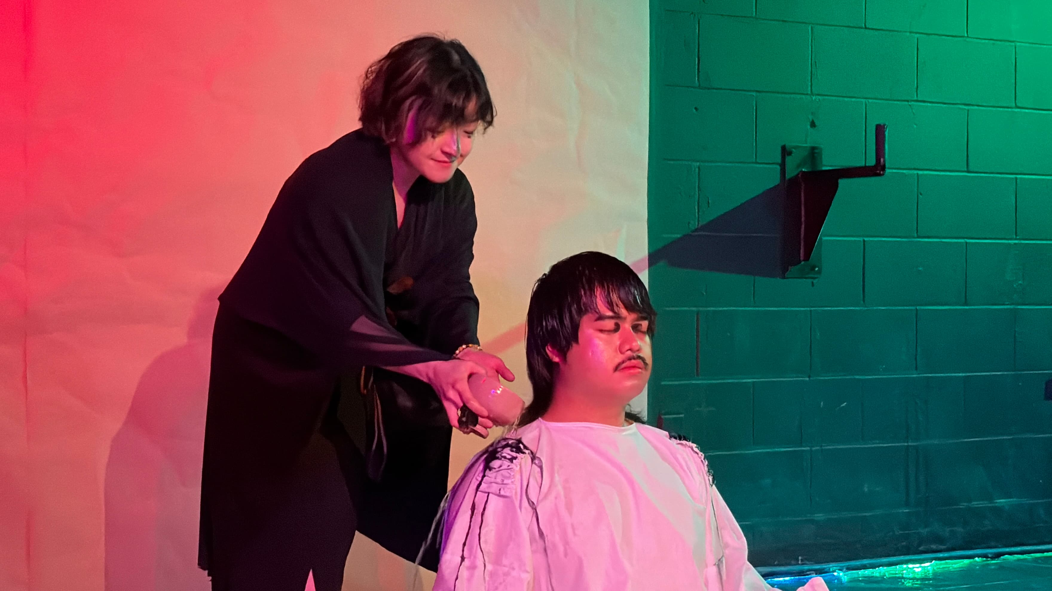 Chikako applying sumi ink to a dancer's shoulder as ink runs down their white costume during the Currents performance
